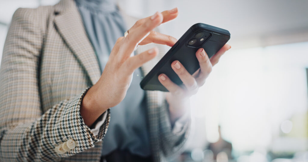 Frau tippt etwas auf ihrem Firmenhandy