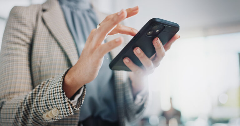 Frau tippt etwas auf ihrem Firmenhandy